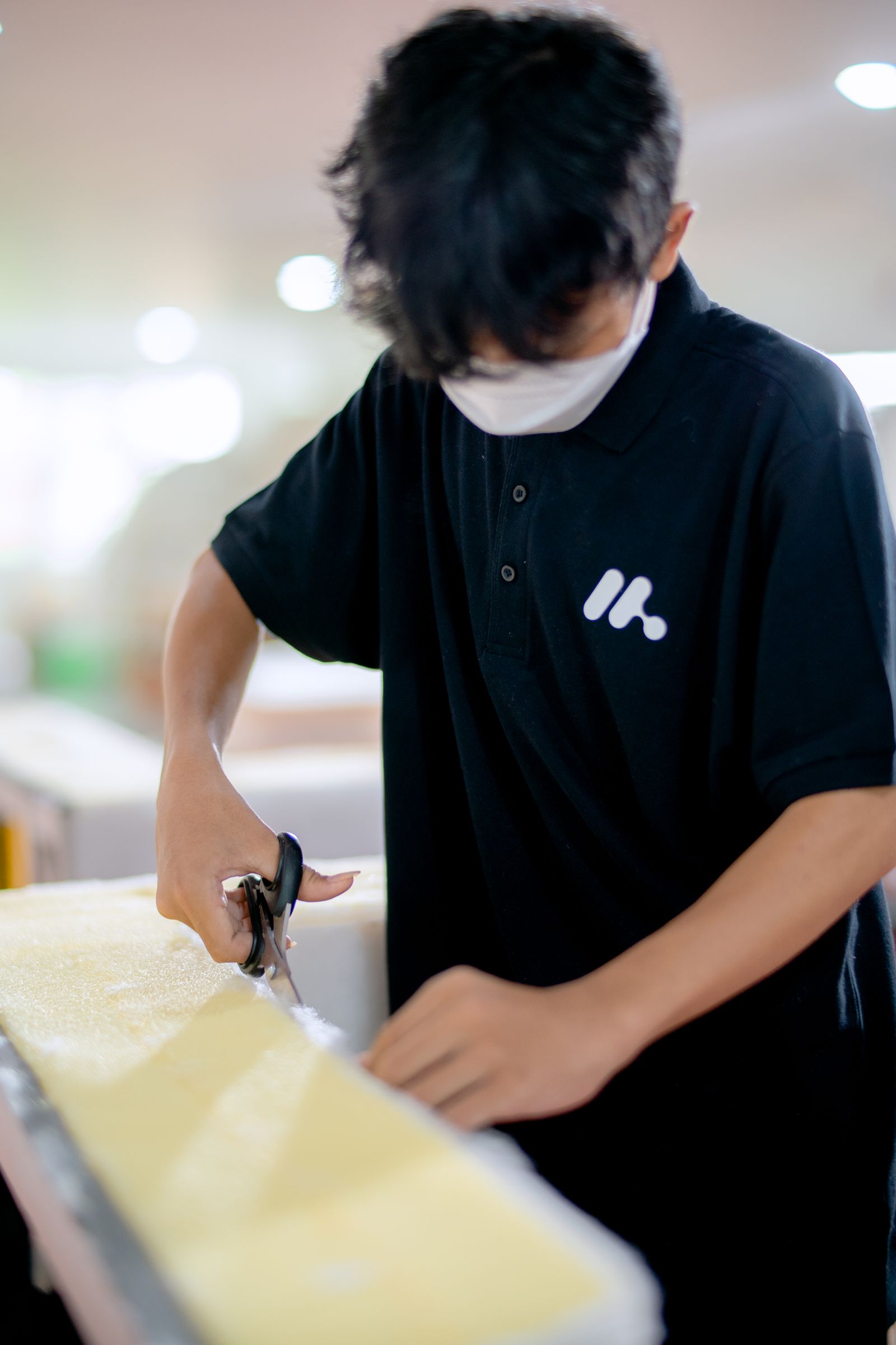 A worker cutting a sheet of foam